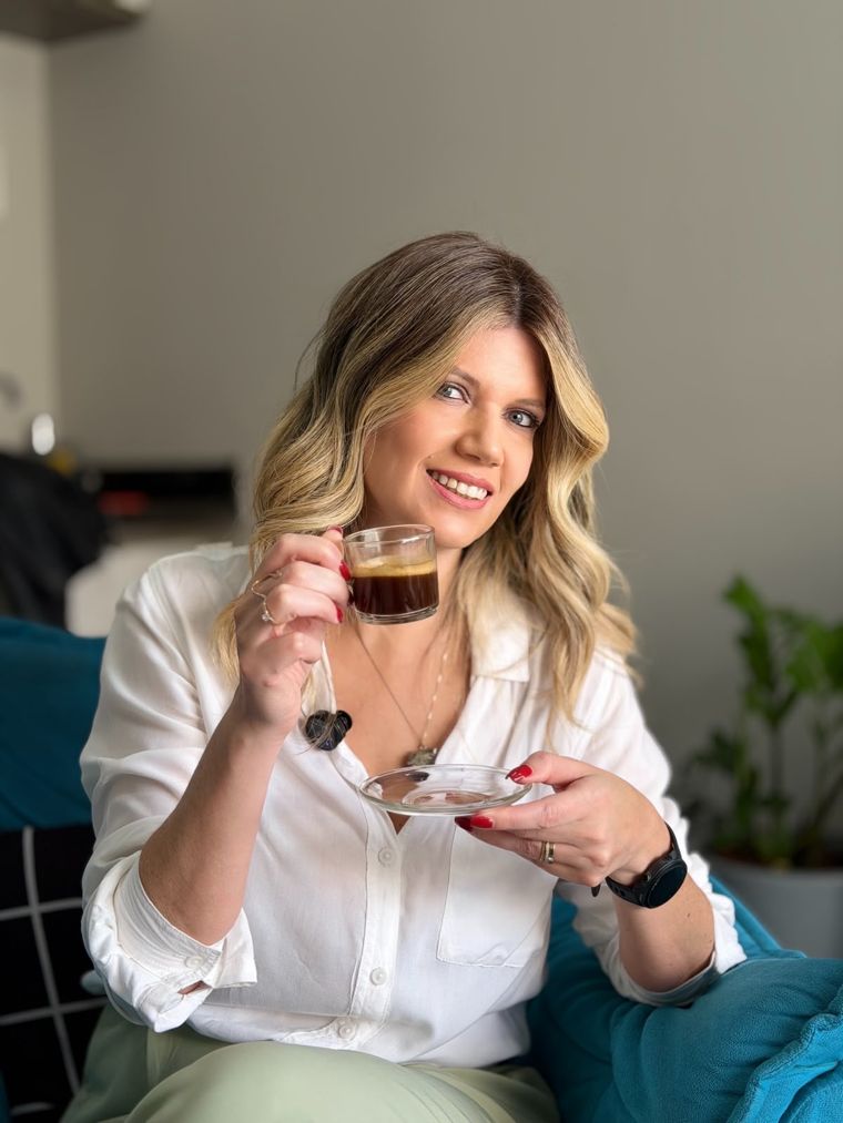 Mayara Pontes sorrindo, com uma xícara de café